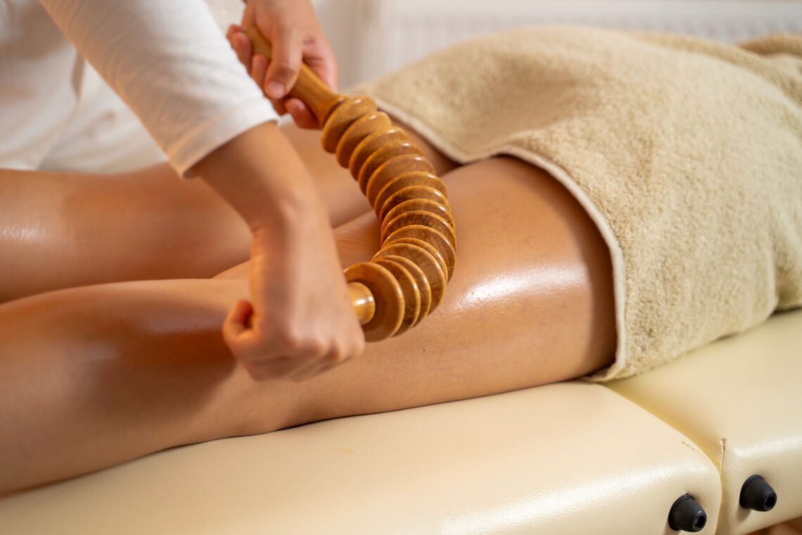Frau bei professioneller Anti Cellulite Massage mit Holzrolle in Wellnesspraxis in Nürnberg