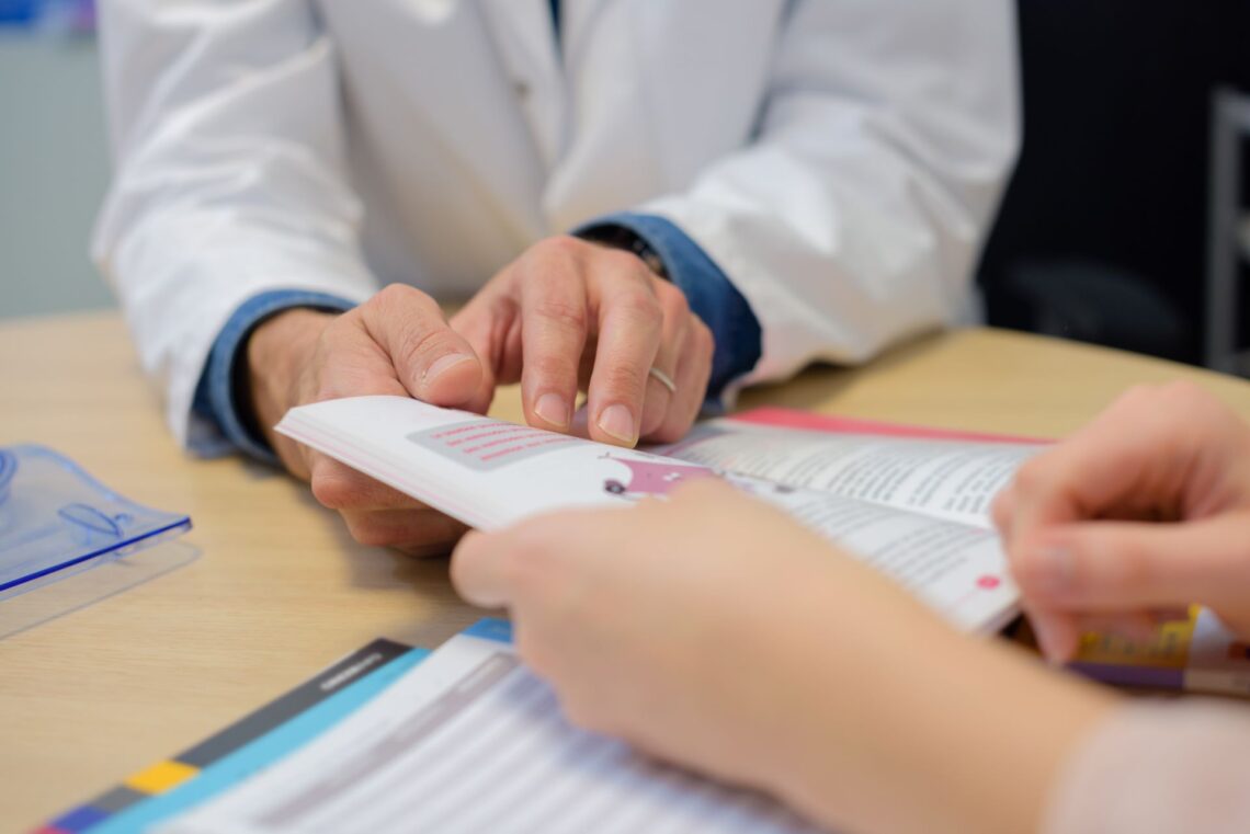 Arzt zeigt Patient medizinische Broschüre