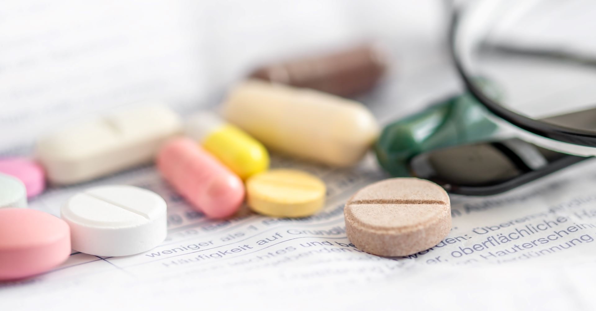 Tabletten liegen auf medizinischem Beipackzettel